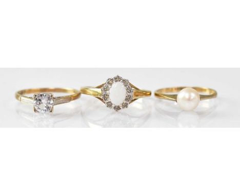 A 9ct yellow gold ring set with an oval opal, surrounded by tiny white stones, size T, a 9ct yellow gold ring set with a sing