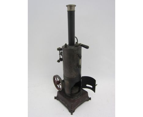 A Bing style stationary engine, maroon painted cast iron base with vertical boiler with chimney, powering a vertically situat