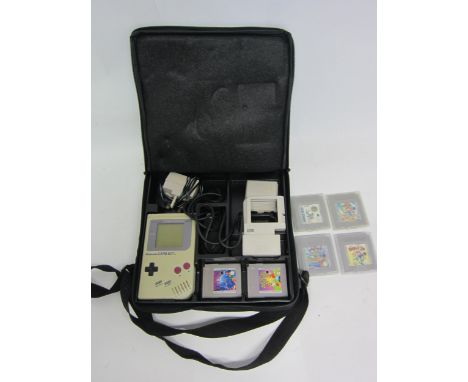 A Nintendo Gameboy handeheld computer games console with power adapter, Gamester power pack, Nuby game light and games to inc