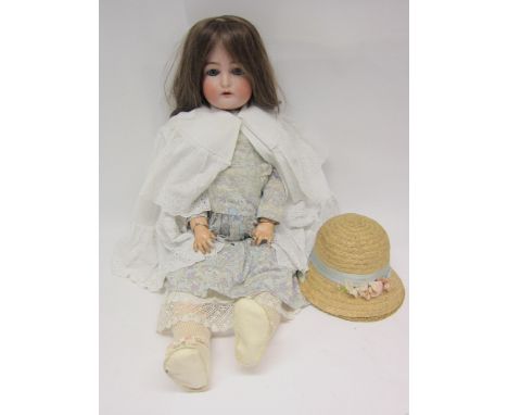 An early 20th Century Simon and Halbig for Kammer and Reinhart head girl doll with brown wig, striated blue glass sleepy eyes