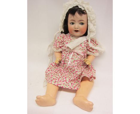An early 20th Century Simon and Halbig for Kammer and Reinhardt bisque head doll with brown wig, striated blue glass sideways