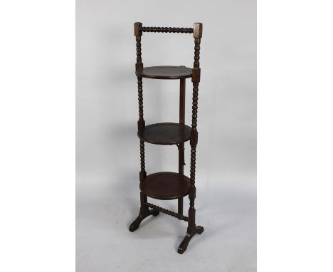 An Edwardian Mahogany Three Tier Cake Stand with Bobbin Supports and Handle, 97cms High 