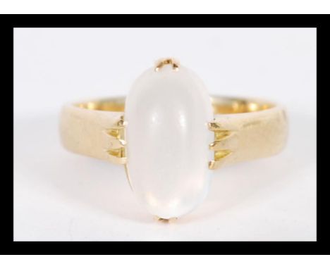 An hallmarked 18ct gold ring with a white polished cabochon stone set within a prong setting. Size O.5 and weighing 6.4g