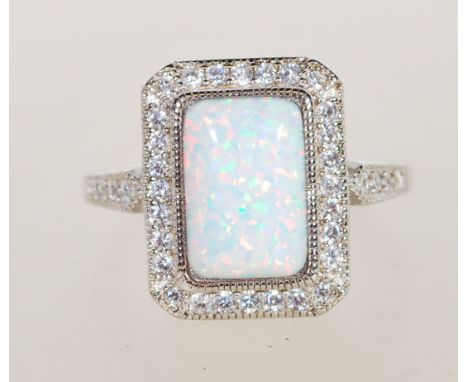 A sterling silver Art Deco style ring having a central opal panel and decorated with CZ stones. Weighs 8 grams size R.5.