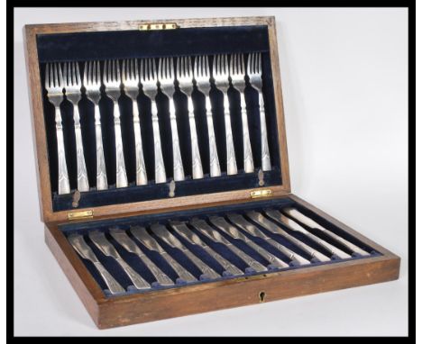 A vintage early 20th Century silver plated canteen of cutlery in oak case consisting of twelve knives and forks.