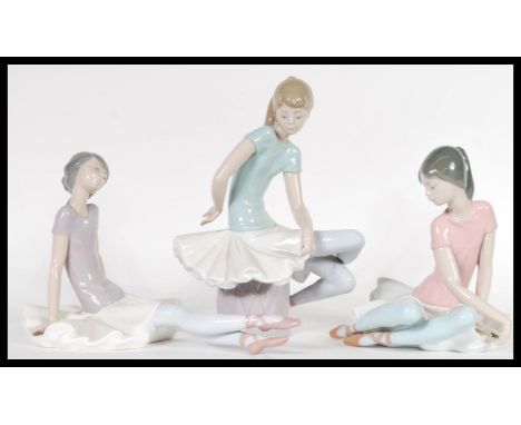A collection of three 20th Century Lladro ceramic figurines of young ballerina girls in relaxed seated poses together with bo