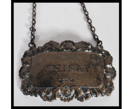 A 20th century silver hallmarked decanter label, having graved notation reading whisky, with decorative scroll work and shell