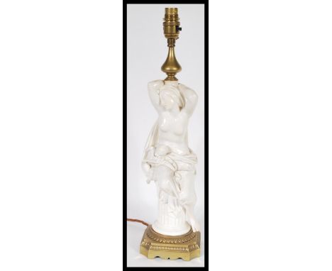 A 19th century Victorian table lamp centerpiece&nbsp; having a white glazed nude figurine in classical pose with cherub on he