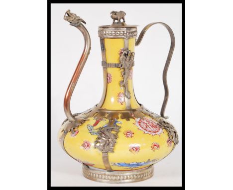 A 20th Century Chinese / Tibetan famille Jaune teapot having silver white metal mounts depicting dragons and serpents with pi