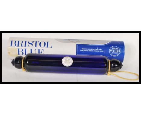 A 20th Century Bristol Blue glass rolling pin, by Thomas Webb with moulded ends, within its original box. 33cm long.&nbsp;