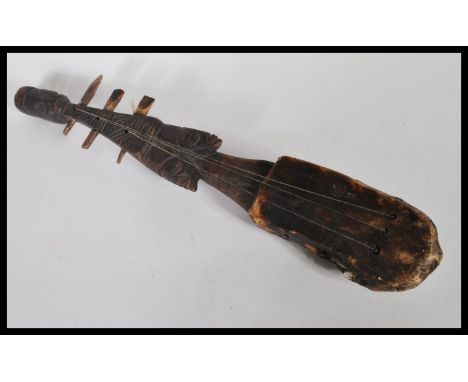 Tribal Art - a vintage 20th Century African Adungu-type string instrument fitted with three strings, carved figural stem, hid