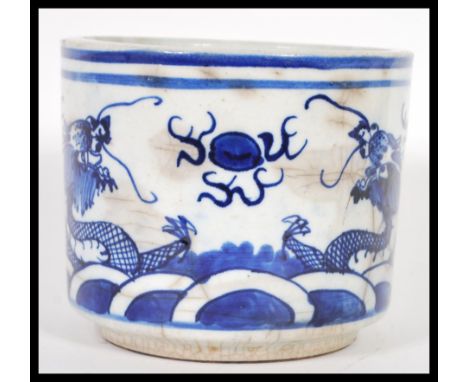 A 19th Century Chinese ceramic brush pot, blue &amp; white glaze with decoration of two dragons chasing a flaming pearl. 12cm