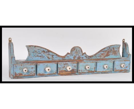A vintage 20th Century wall hanging painted distressed pine spice shelf. The shelf having a run of five drawers fitted with c