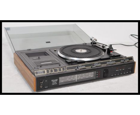 A retro 20th Century ITT 5042 Stereo Music Centre, smoked perspex lift up lid with a fitted BSR&nbsp; record deck, tape playe