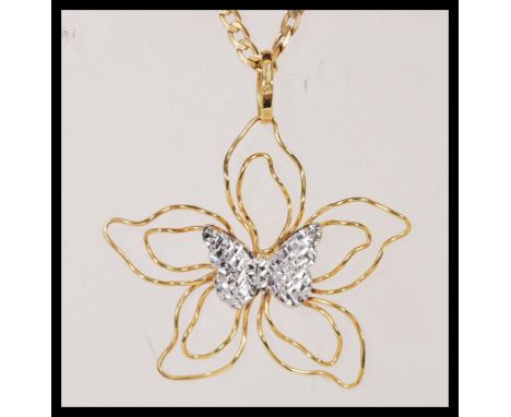 A stamped 375 9ct gold pendant necklace having a flat linked chain with a stamped 375 9ct gold floral pendant with a silver t