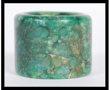 A 19th Century Chinese large mottled dark green jade archers thumb ring. 2.5cm high 3.5cm diameter.&nbsp;