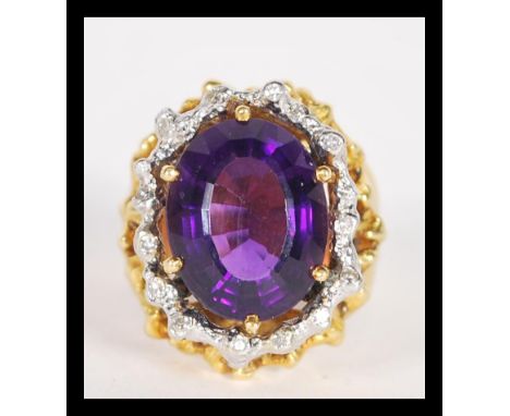 A fantastic 18ct gold large dress ring having a large central faceted amethyst with white gold illusion set diamonds and bark