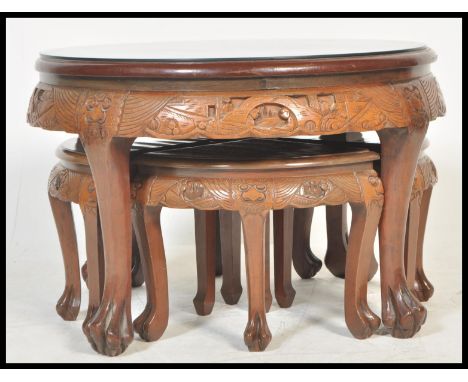 A 20th Century Carved Chinese hardwood coffee table / nest of tables, intricately carved to the top with warriors on horsebac