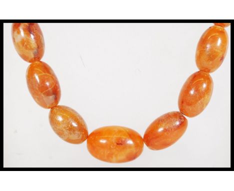 A vintage amber / faux amber Chinese prayer bead necklace having a graduating strand of beads. Measures 71cm long.