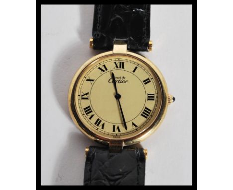 A vintage Must de Cartier wrist watch having a round face with roman numerals to the chapter ring and faceted hands within a 
