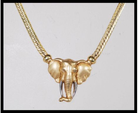 A 9ct gold necklace with a flat link chain attached to a pendant in the form of an elephant. Stamped 375. Weight 13.4g. Chain