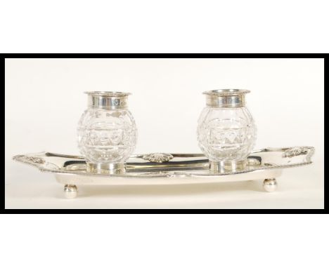 A 19th Century Victorian hallmarked silver ink stand by William Hutton &amp; Sons having two cut cut glass and silver rimmed 