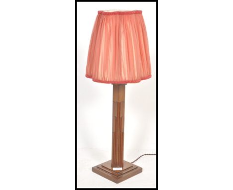 A 1930's Art Deco oak table lamp being raised on a square base with shaped column and shade atop.&nbsp;Measures: 67cm tall.
