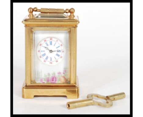 An 8 day brass cased miniature carriage clock having hand painted Limoges enamel porcelain plaques. The white enamel face hav