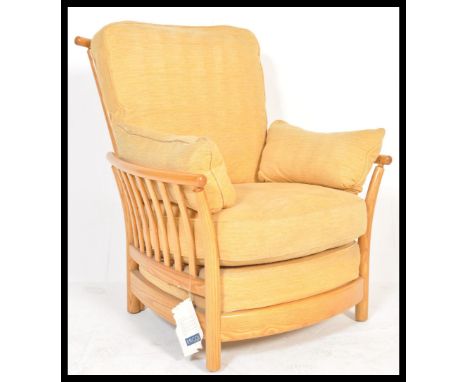 A large Ercol Renaissance light elm armchair complete with fabulous covers in very good condition, the frame with railed gall