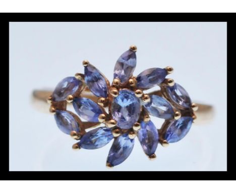 A stamped 9k 9ct gold ring set with a cluster of lilac stones. Total weight 2.3g. Size P.