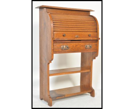 An early 20th Century Arts &amp; Crafts oak students tambour fronted bureau, with shelf and a fall front and open shelves ben