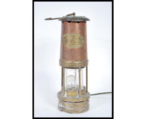 A vintage early 20th Century brass miners lamp having applied brass plaque being later converted to electricity. 25cm high.&n