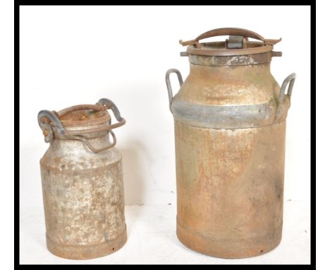 Two vintage 20th Century galvanised metal milk churns complete with lids and clasps.