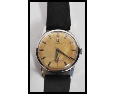 A vintage 20th Century Omega watch having a champagne dial with silver baton numerals and faceted hands with subsidiary dial 