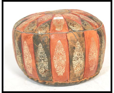 A vintage mid 20th Century Moroccan patchwork leather pouffe, the pouffe decorated with tooled leather patches in a geometric
