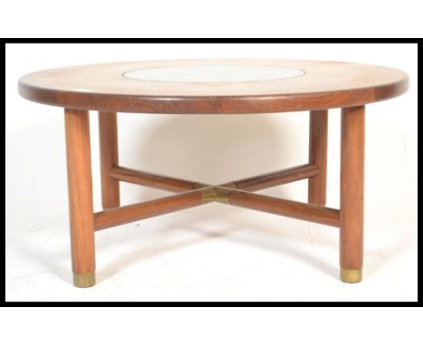 A vintage retro 20th century teak wood G-Plan Astral coffee table of circular form with inset glass top being raised on shape