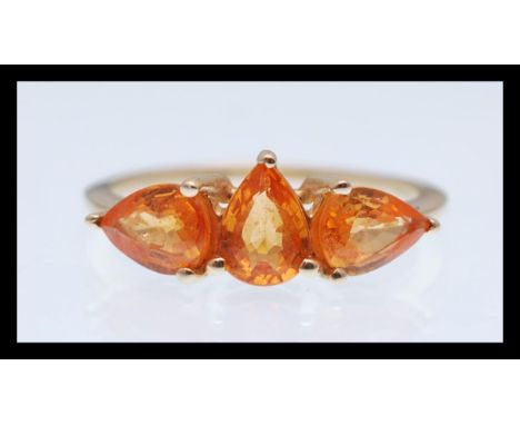 A 9ct gold hallmarked ring prong set with three pear shaped orange stones. Hallmarked Birmingham 2015. Weight 2.4g. Size P.5.