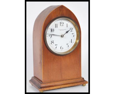 An Edwardian mahogany inlaid spire shaped mantel clock with enamel dial being marked for Pleasance &amp; Harper, Bristol. 21c