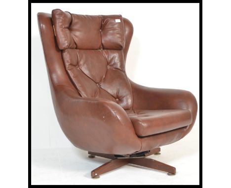 A retro / vintage 20th Century Parker Knoll Statesman swivel easy chair, upholstered in a tan button back vinyl raised on a q