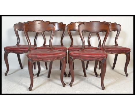 A set of six 19th Century Victorian mahogany kidney / balloon back dining chairs raised on cabriole legs with scrolled back r