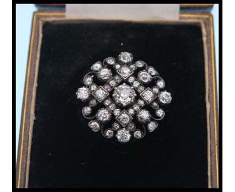 A 19th Century Victorian gold silver and diamond cluster brooch pendant having prong and collet set diamonds with a central o