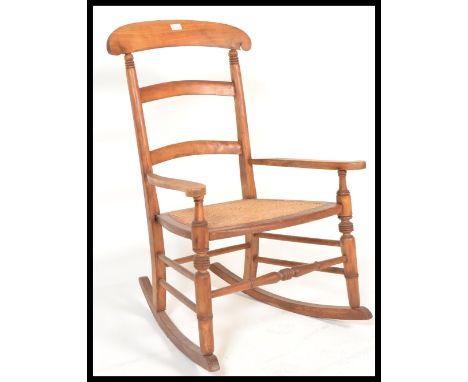 A 19th Century Victorian fruitwood and cane work rocking chair, cane seat panel between open arms with turned supports, bobbi