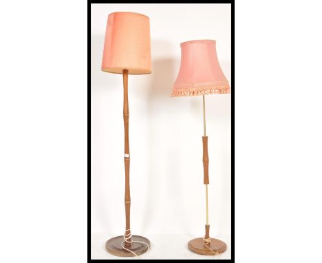 A 1970's teak wood standard lamp raised on terraced base with turned column and tapering shade together with another teak mid