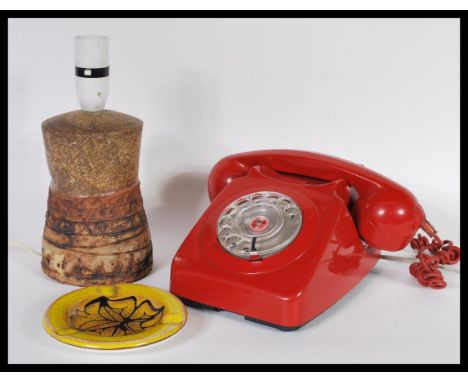 A vintage 20th century BT ring dial telephone in a red colourway together with a Poole pottery Aegean ashtray and a Bernard R