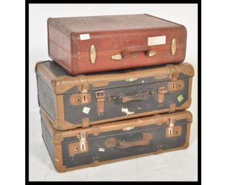 A vintage stack of suitcases dating from the 20th century to include leather and two tone examples along with a small doctors