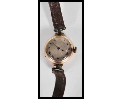 A 9ct gold hallmarked ladies wristwatch/ cocktail watch. Having a circular face with roman numeral chapter ring and leather s