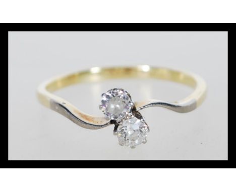 A stamped 18ct gold and platinum ring prong set with two brilliant cut diamonds.Weight 2.3g. Size Q.5.&nbsp;