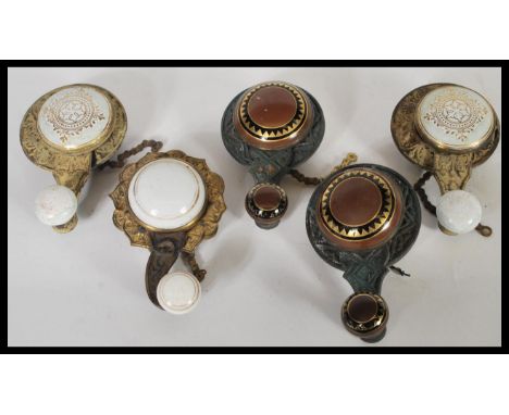 A collection of five antique Edwardian interior bell pulls having brass body and ceramic knob handle and central piece with g