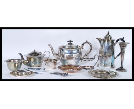 A group of vintage 20th Century silver plated items to include a Harrods of London water jug, teapot, candlesticks, flatware,