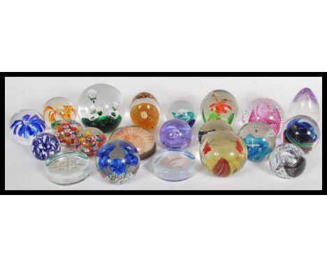 A collection of 20th century glass paperweights to include a pink Caithness control bubble swirl paper weight, a Caithness 'm